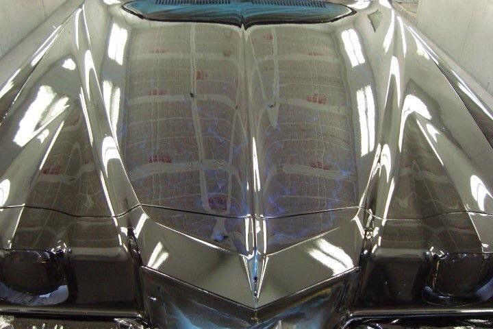 A close up of a black car with the hood up