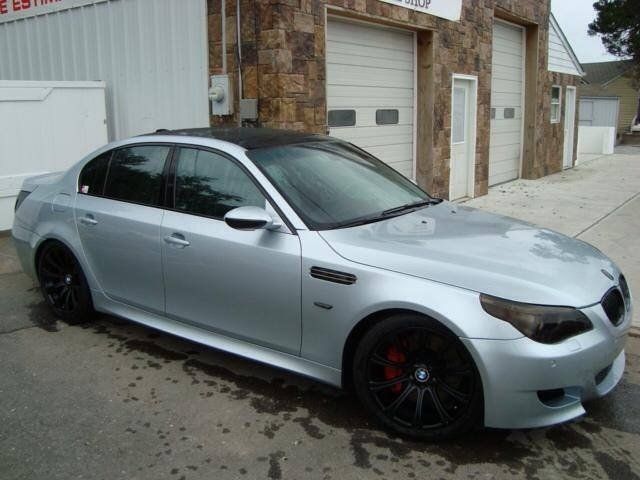 A silver bmw is parked in front of a garage