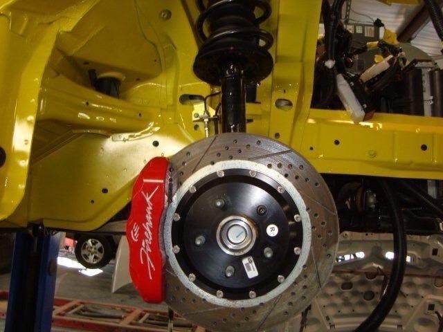 A yellow car with a red brake caliper on it