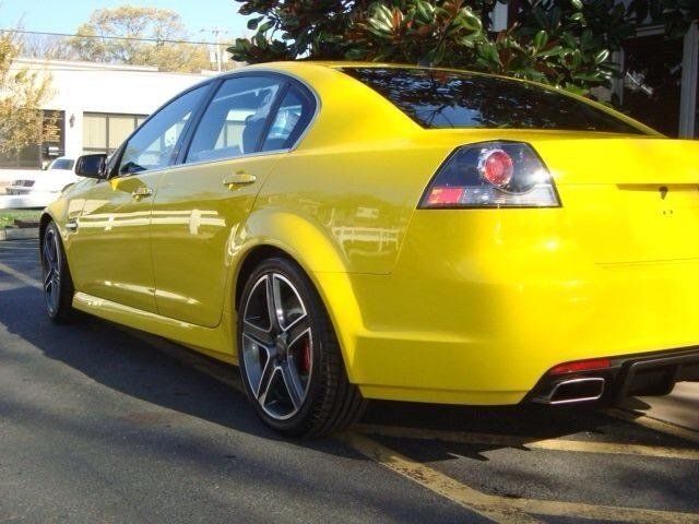 A yellow car is parked on the side of the road