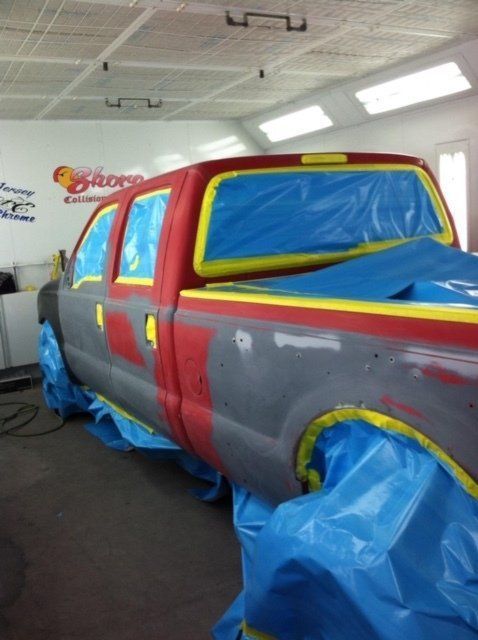 A truck that is being painted in a garage