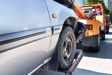 Truck Towing a Broken Car — Cambridge, MD — Jess Jr's & Sons Body Shop