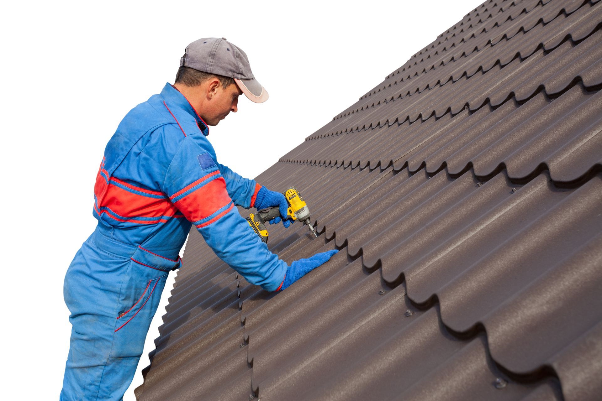 Roofer in blue coveralls installing metal roof tiles with a drill.