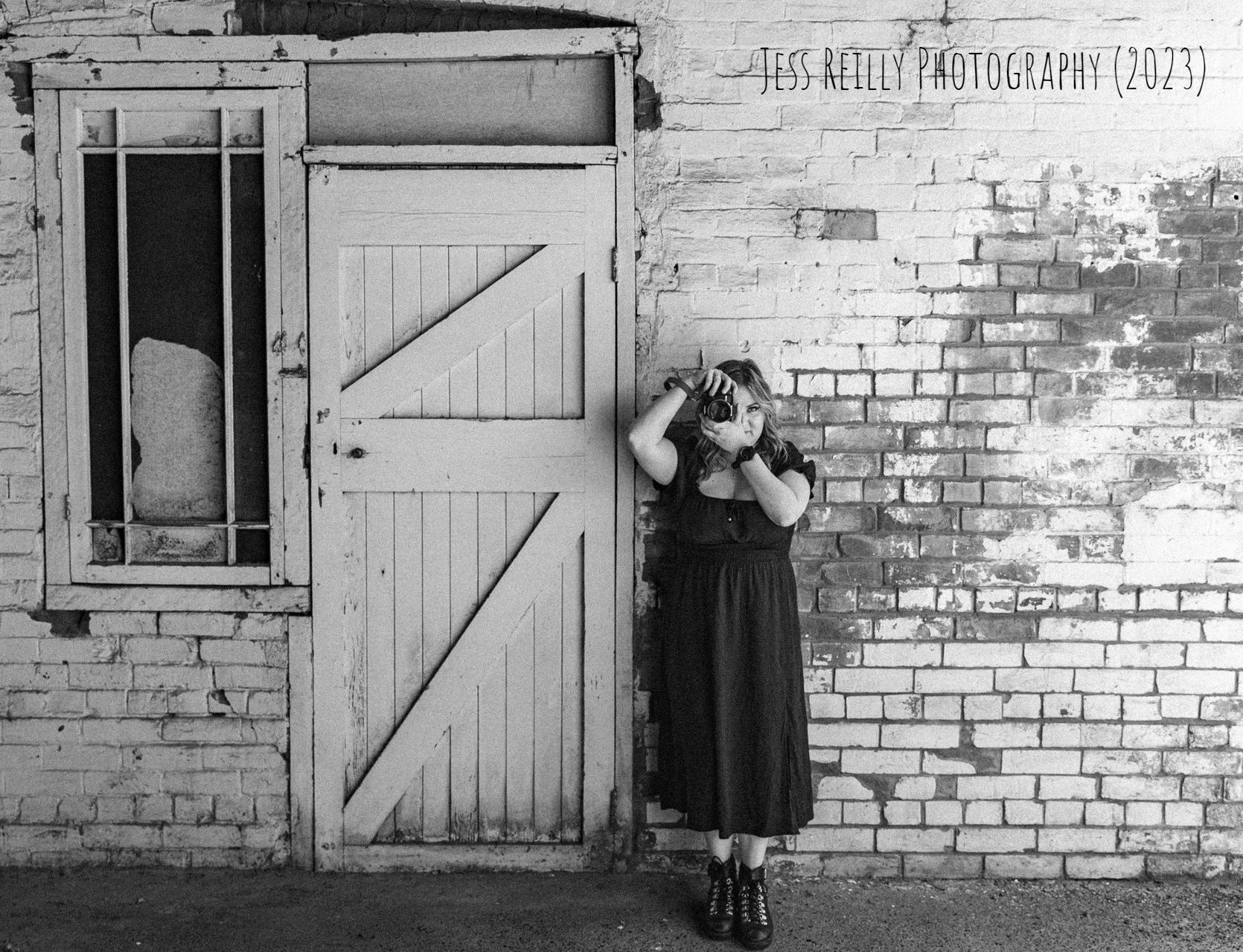 A black and white photo of a woman taking a picture