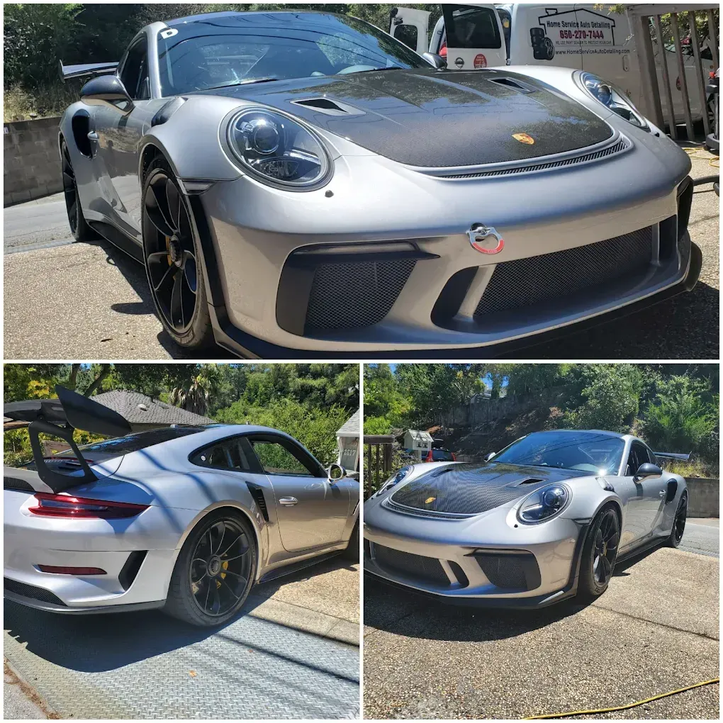 Silver Porsche 911 GT3 RS with carbon fiber hood and rear wing parked outdoors.