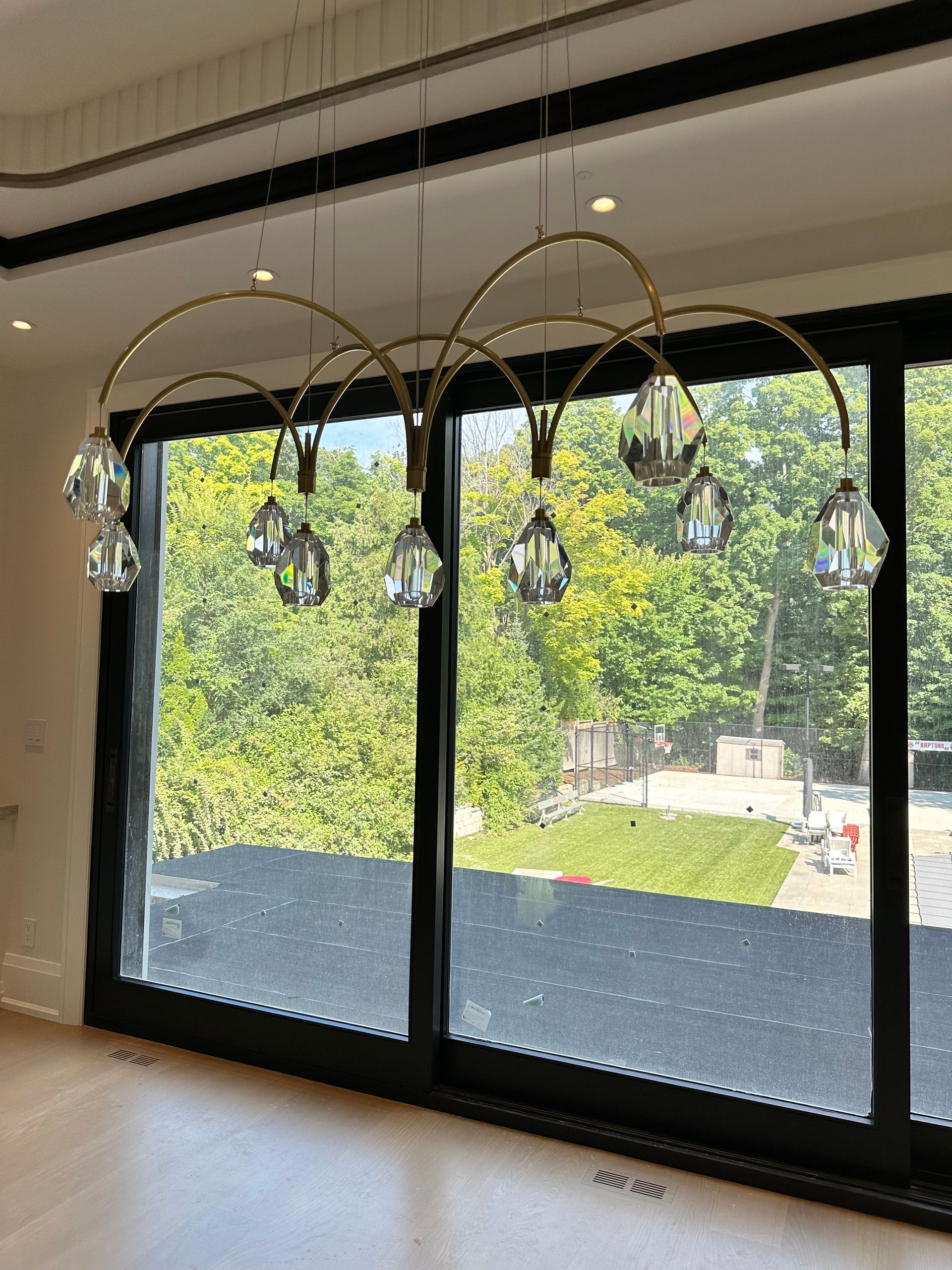 A room with a large window and a chandelier hanging from the ceiling.