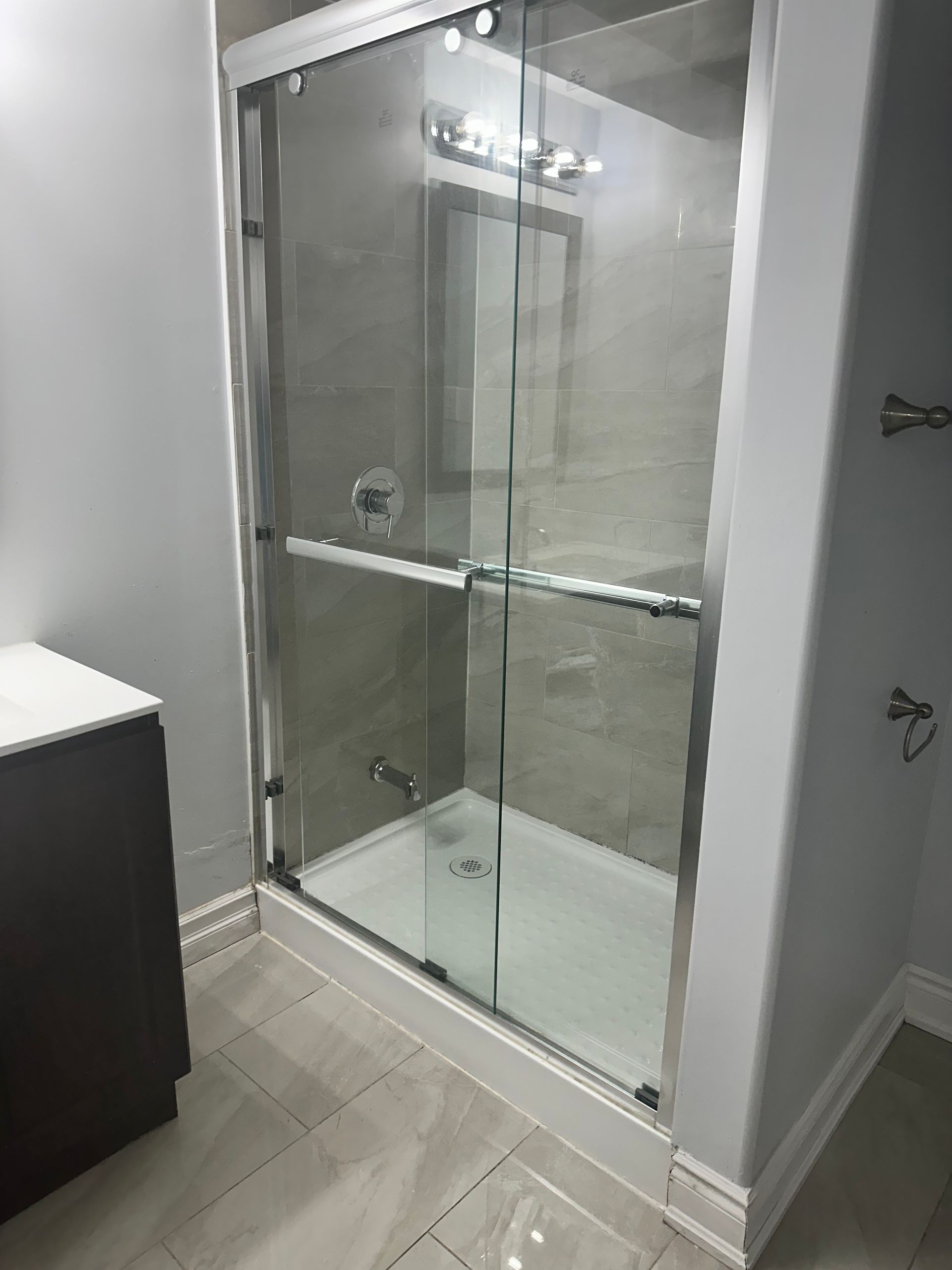 A bathroom with a sliding glass shower door and a sink.
