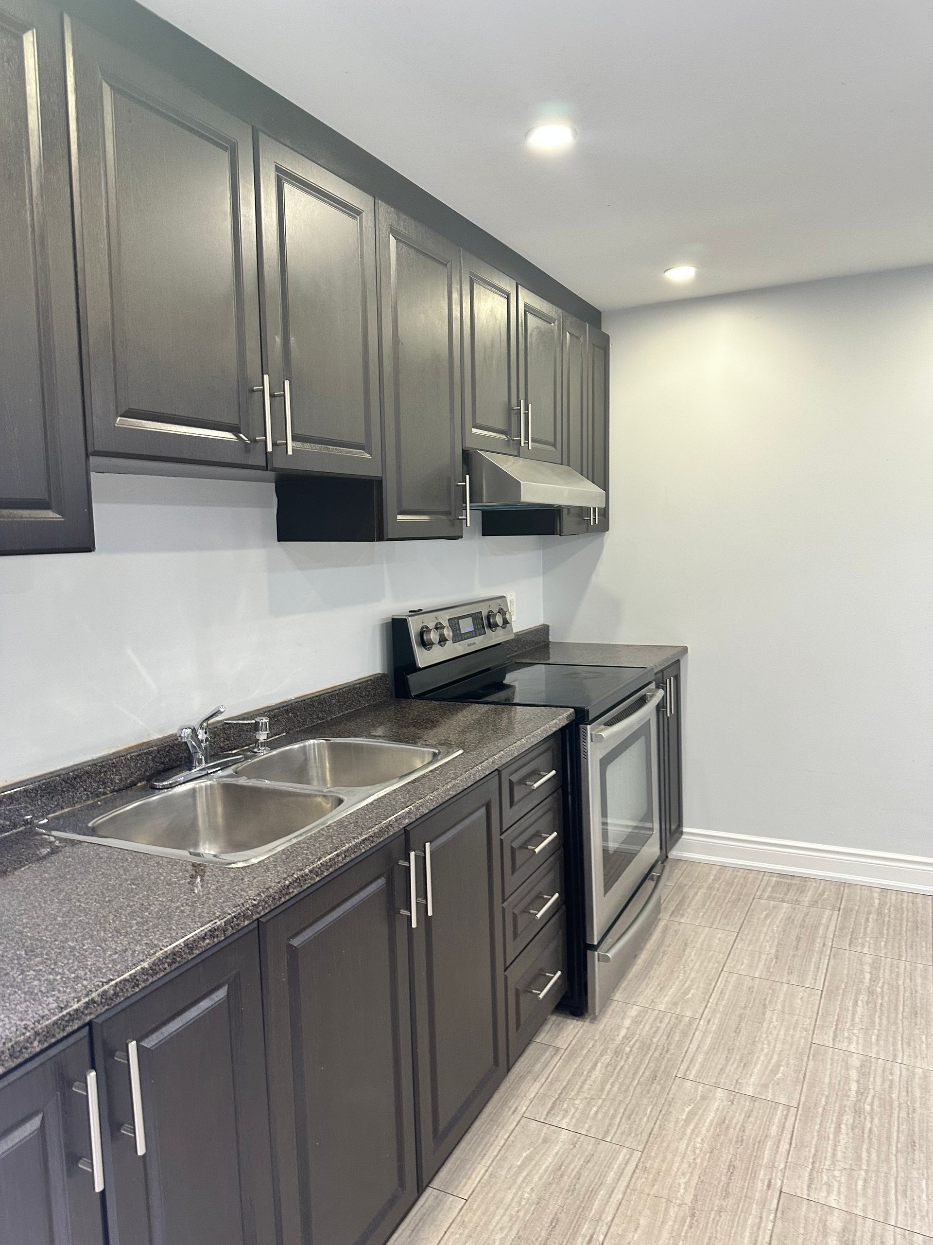 A kitchen with black cabinets and granite counter tops