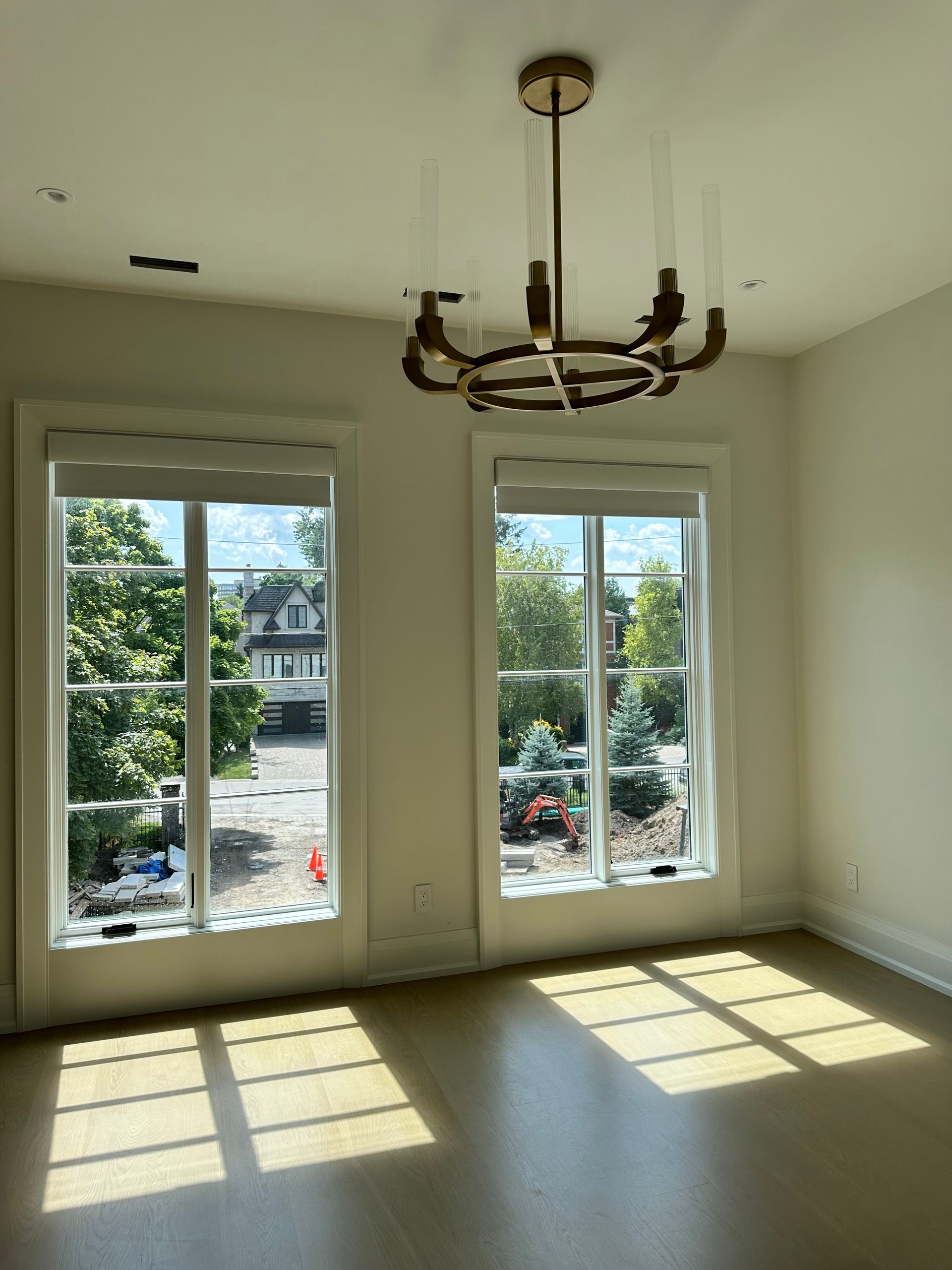 An empty room with lots of windows and a chandelier