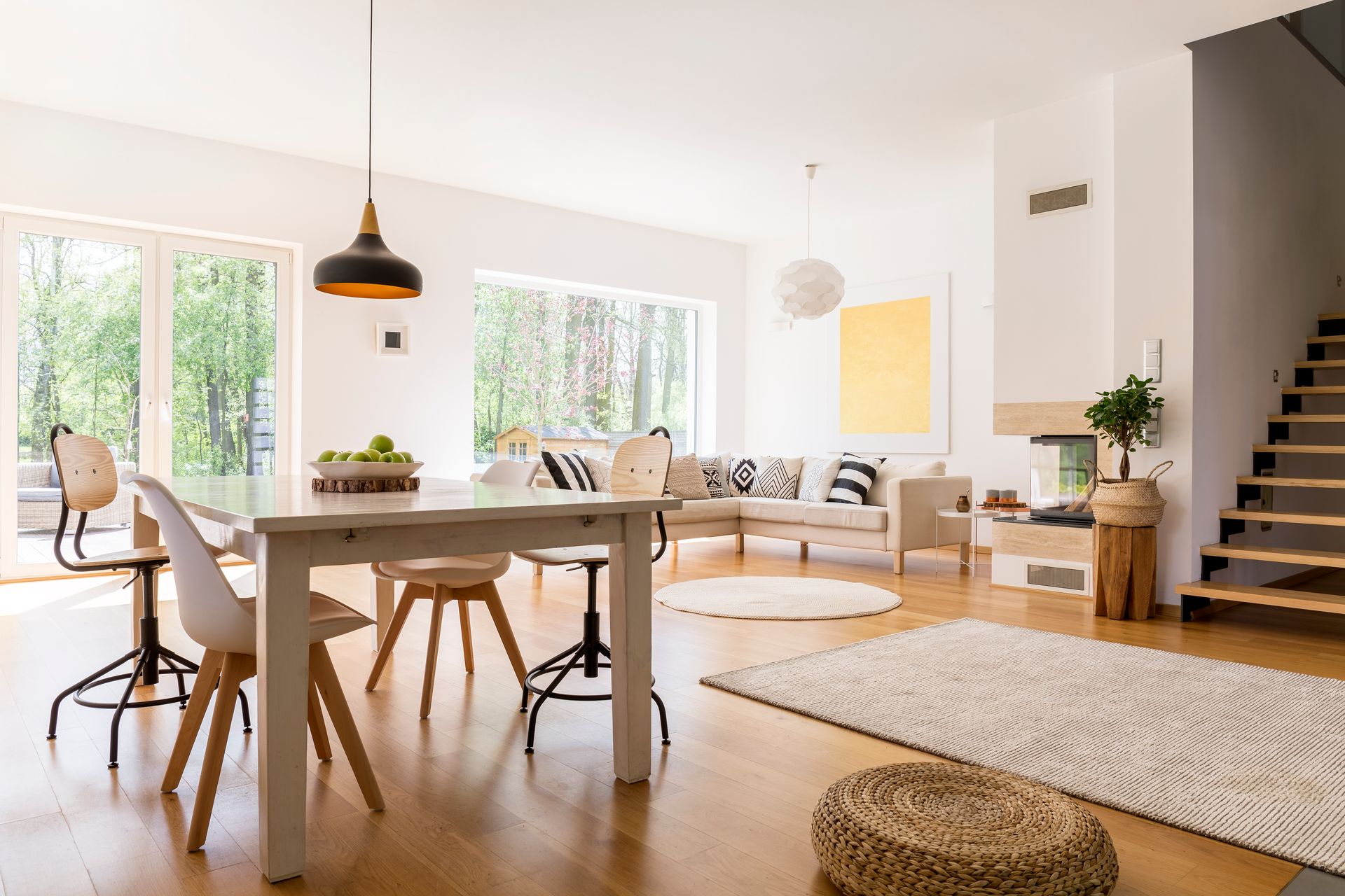 A living room with a table and chairs and stairs.