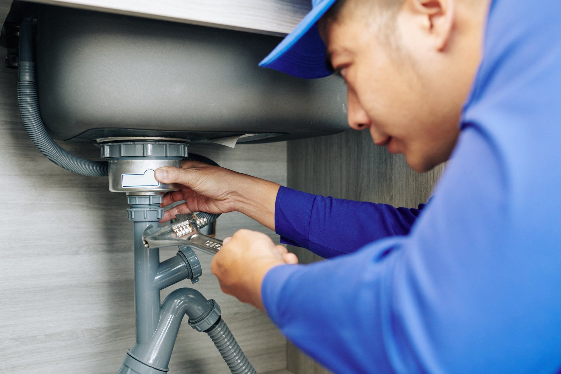 A Man Fixing The Sink — Springville, UT — Blue Plumbing and Drain Cleaning