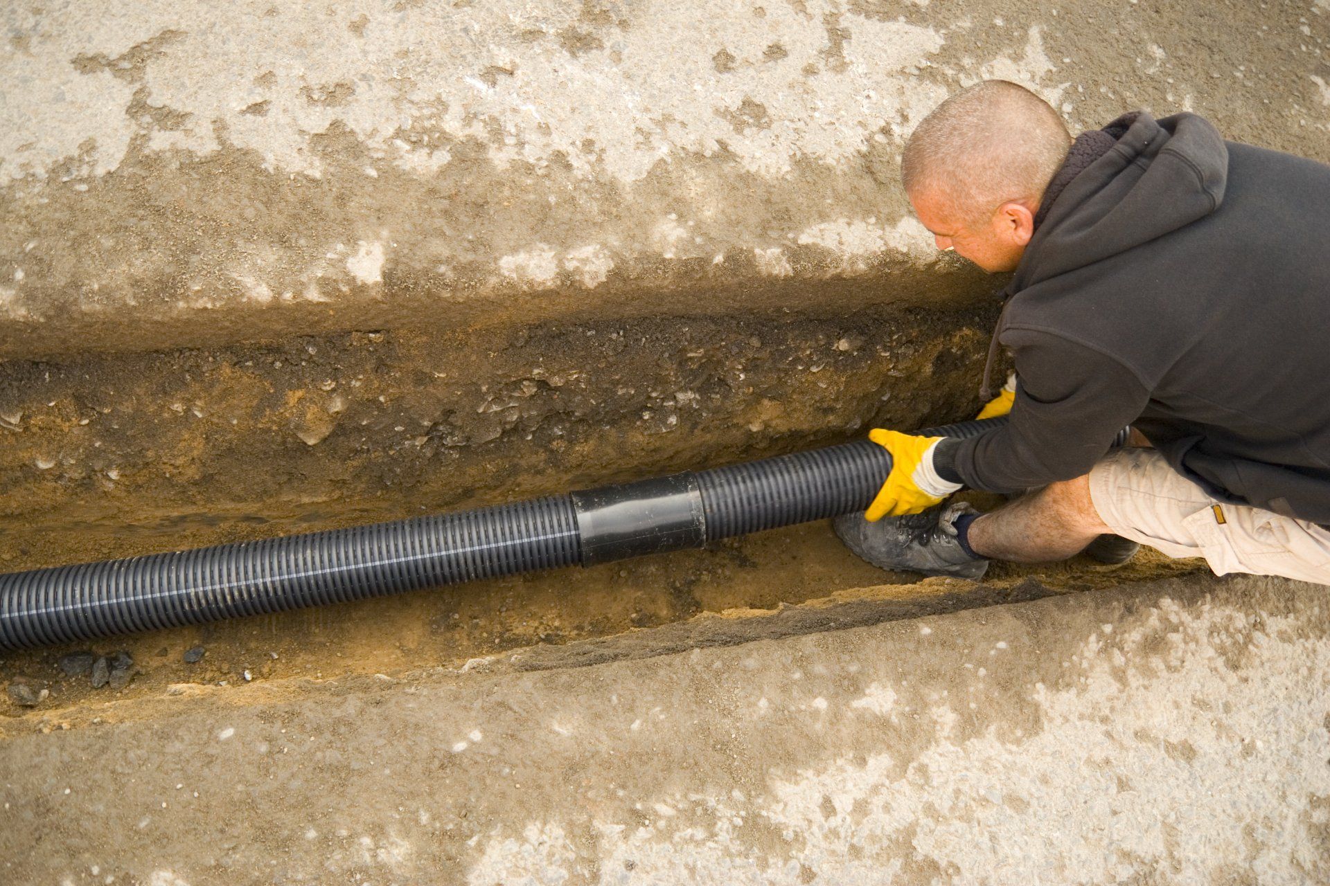 A man is installing a pipe in the ground.