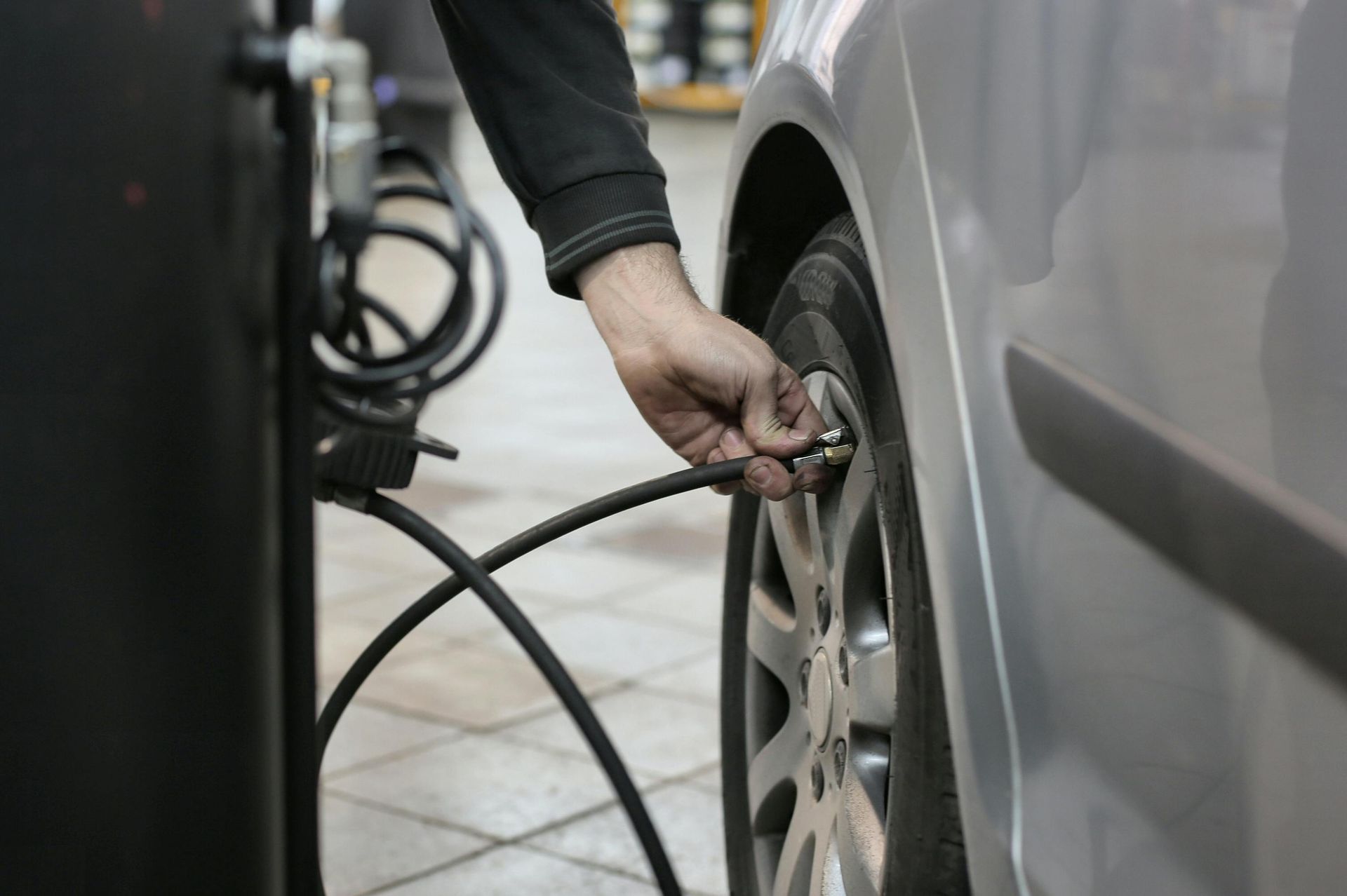 A person is pumping air into a car tire.