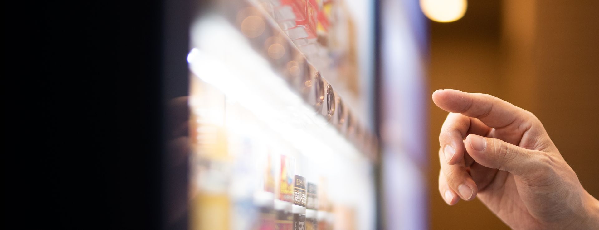 A person is pressing a button on a vending machine.