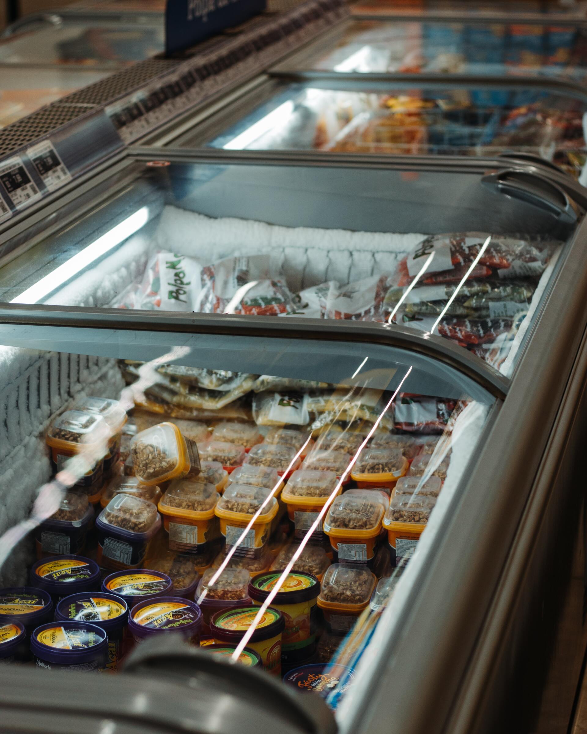 A refrigerator filled with lots of food in a store.