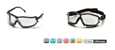 Gafas de seguridad, dos pares, marcos negros con lentes transparentes y una fila de íconos de certificación debajo.