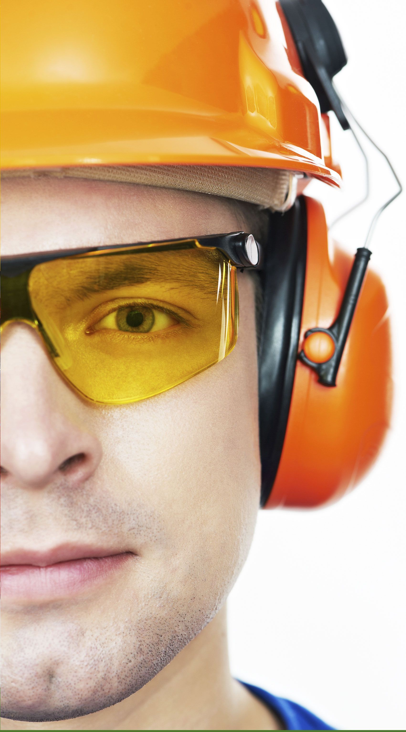Primer plano del rostro de una persona que lleva casco de seguridad de color naranja, gafas y protección para los oídos.
