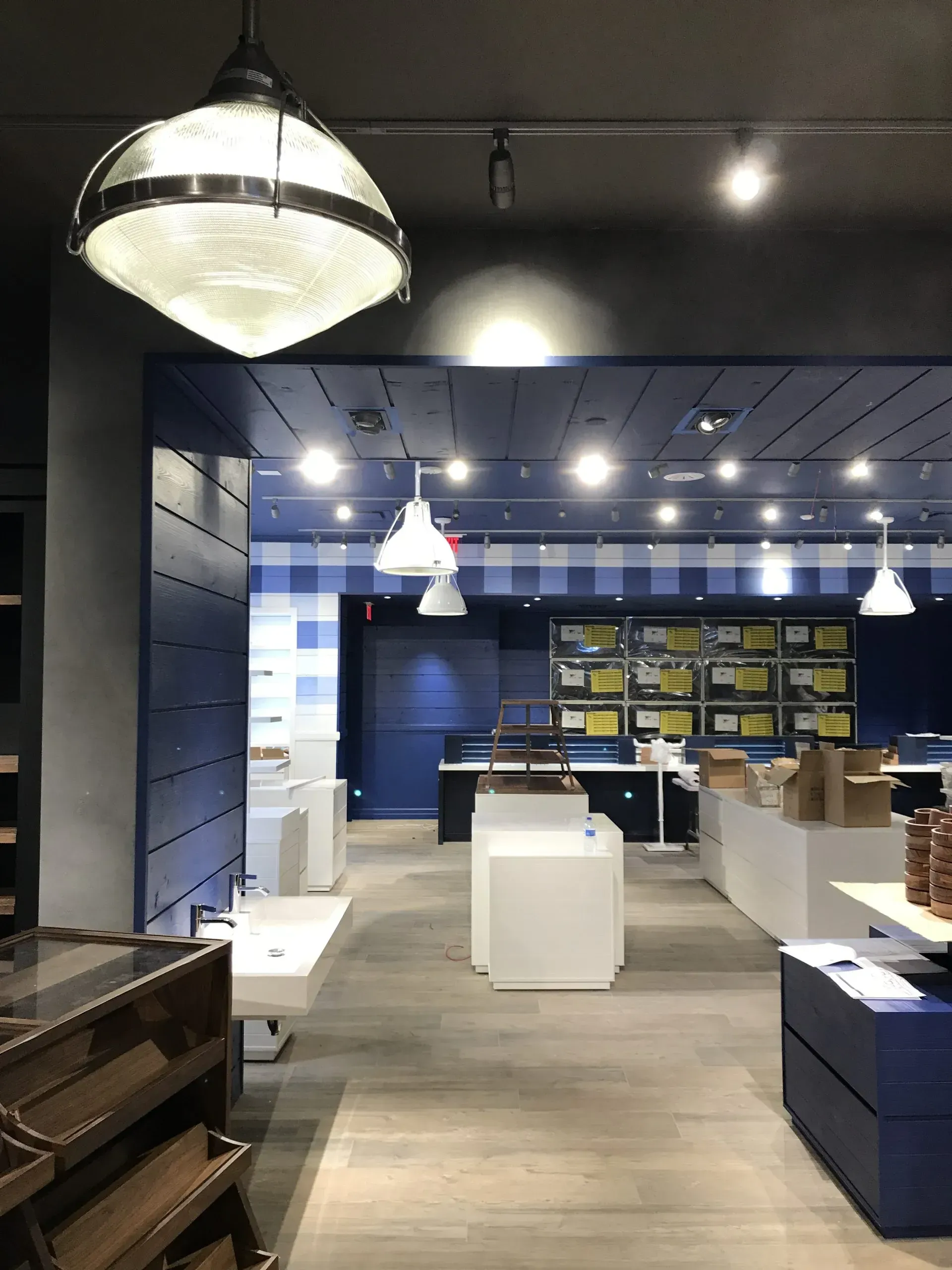 Interior of a Bath & Body Works store with blue and white accents, white displays, and overhead lighting.