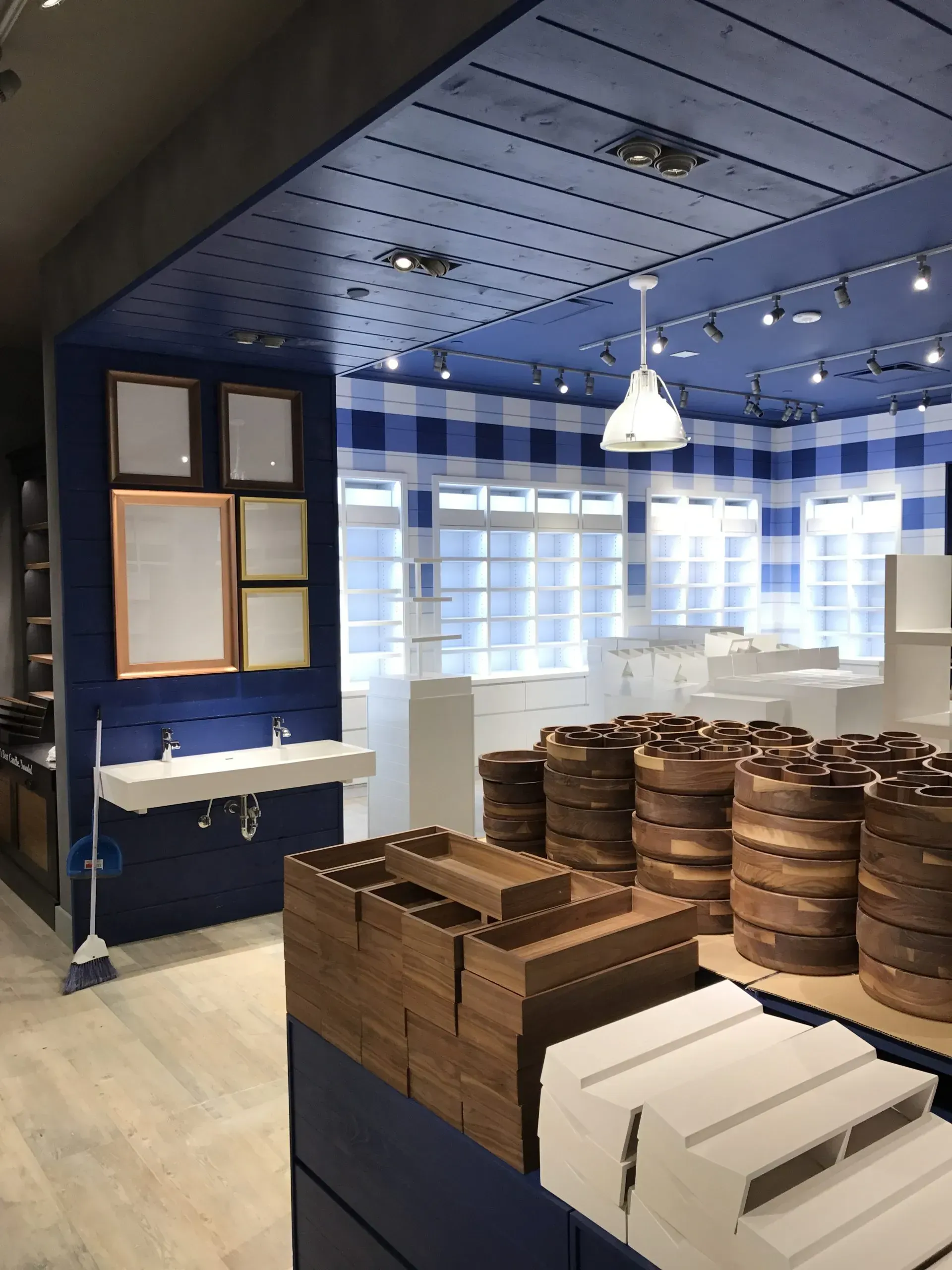 Interior of a Bath & Body Works store with blue and white gingham accents, wooden barrels, and displays.