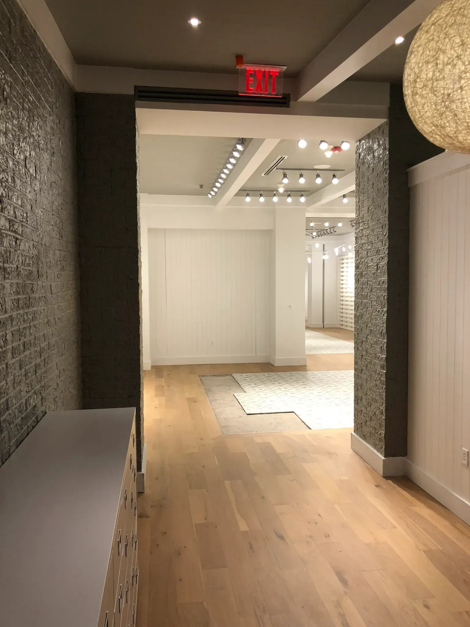 Interior shop entry with wood floor, textured walls, and view of store interior.