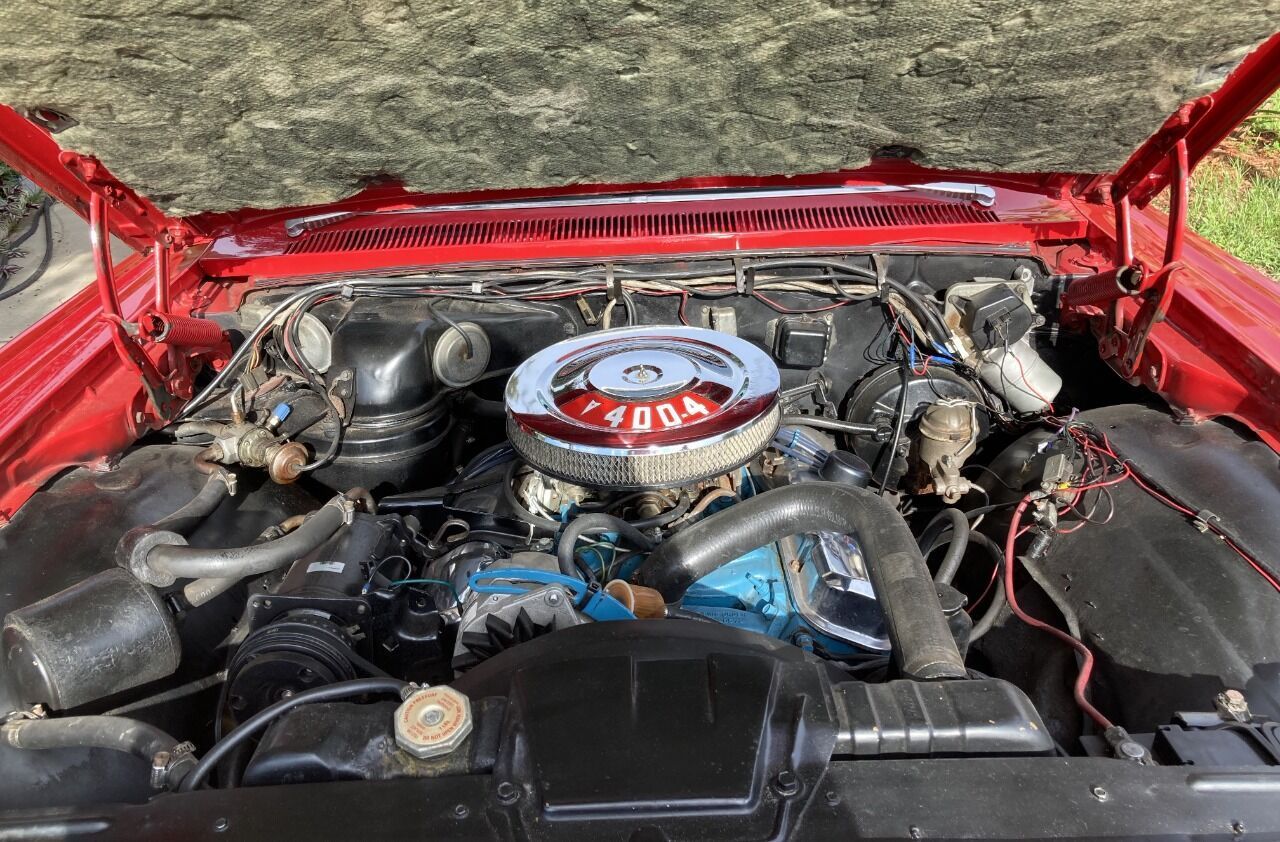 a close up of the engine of a red car with the hood up . | Tampa, FL | CARuso Classic Cars