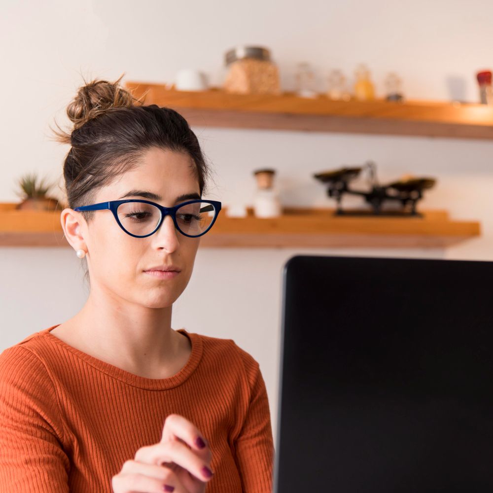 woman looking at computer taking the Beyond the Status Quo on-demand workshop
