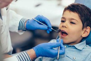Deep Teeth Cleaning — Dentist Checking Child's Teeth in Whiting, IN