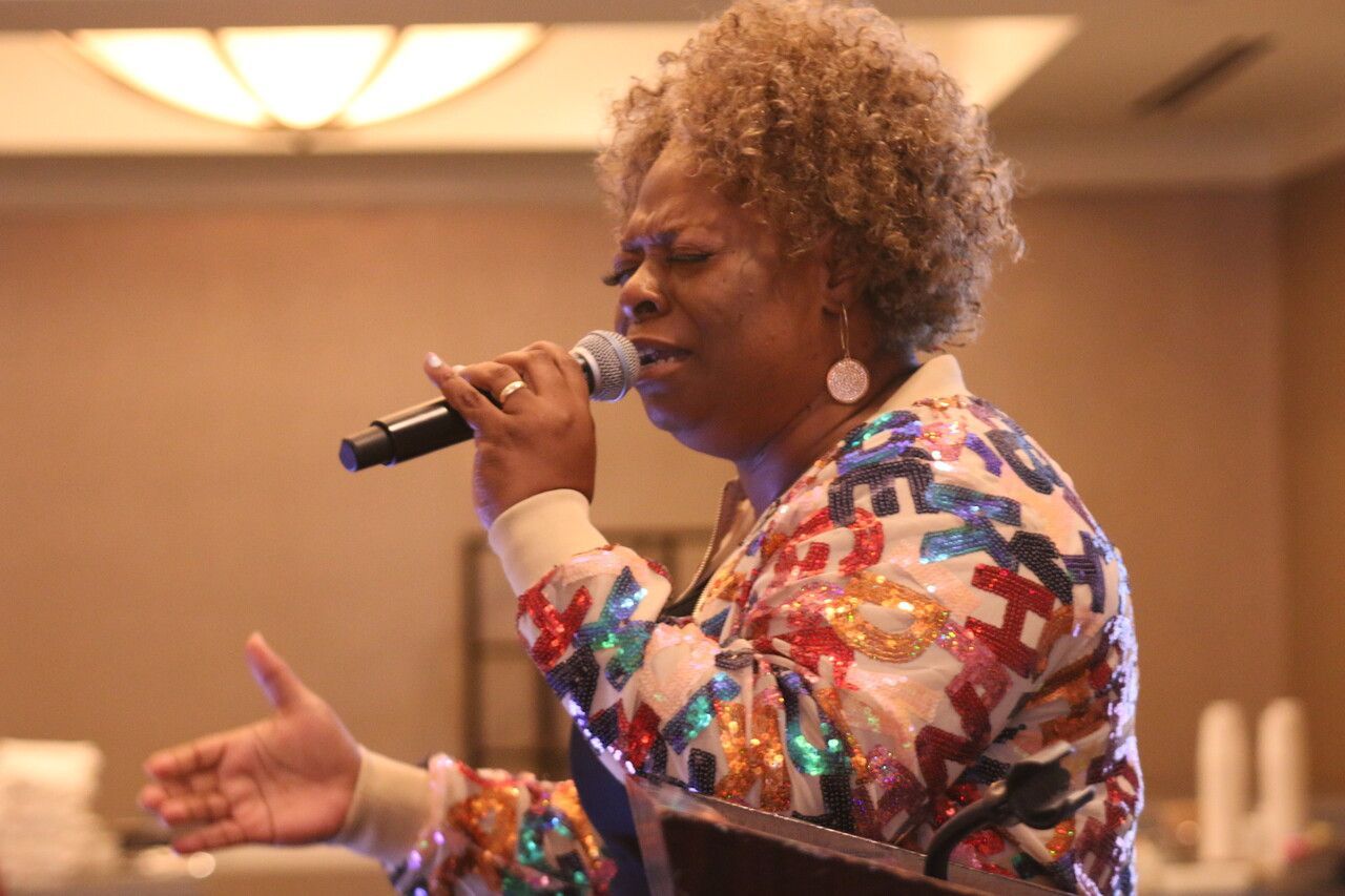 A woman singing at an event at Overflow Christian Center