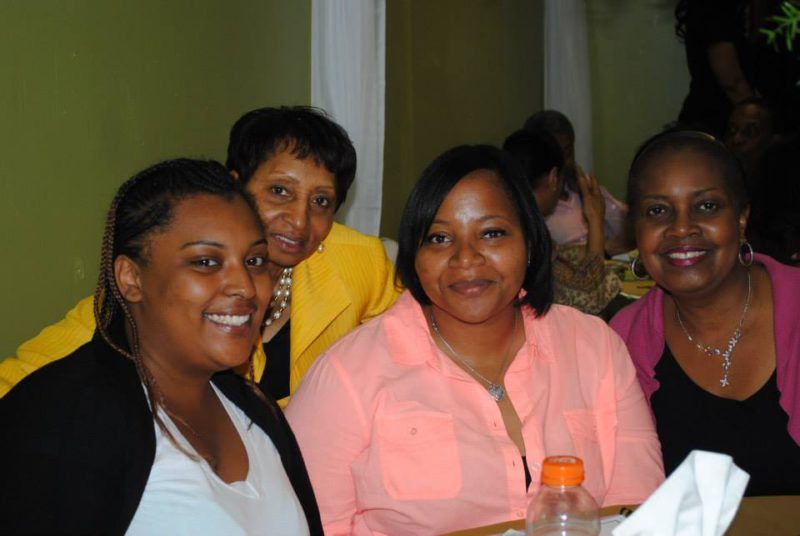 Four women having their picture taken at an event at Overflow Christian Center