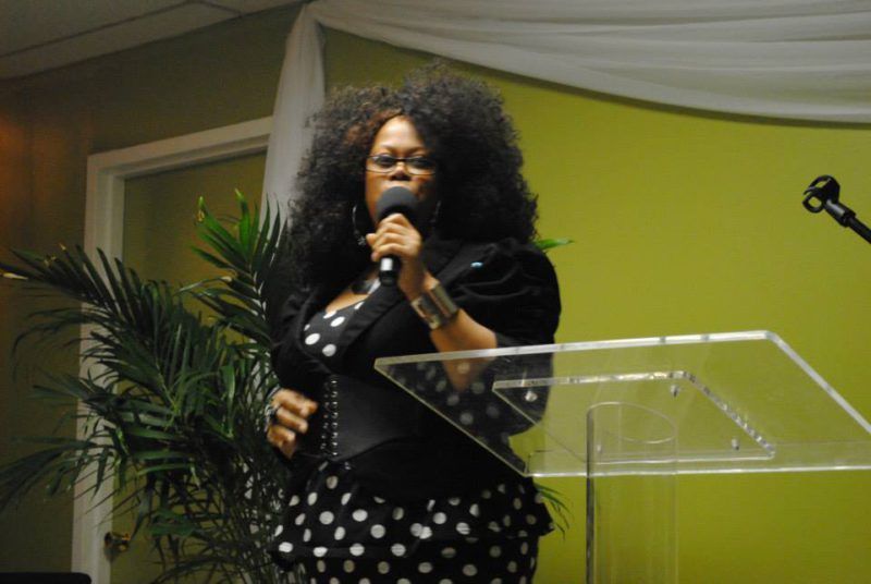 Photo of a lady church member talking on pulpit at Overflow Christian Center