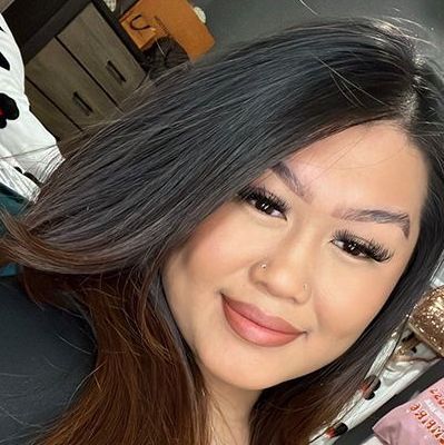 A close up of a woman 's face with long hair and a nose ring.