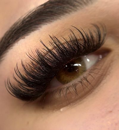 A close up of a woman 's eye with long eyelashes.