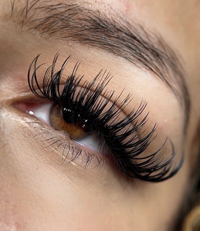 A close up of a woman 's eye with long eyelashes.