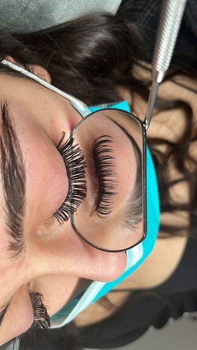 A close up of a woman 's face with glasses and long eyelashes.