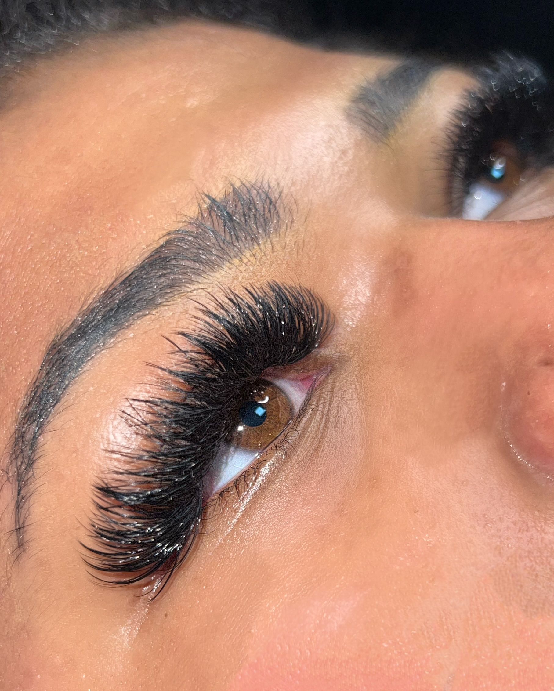 A close up of a woman 's eye with long eyelashes.