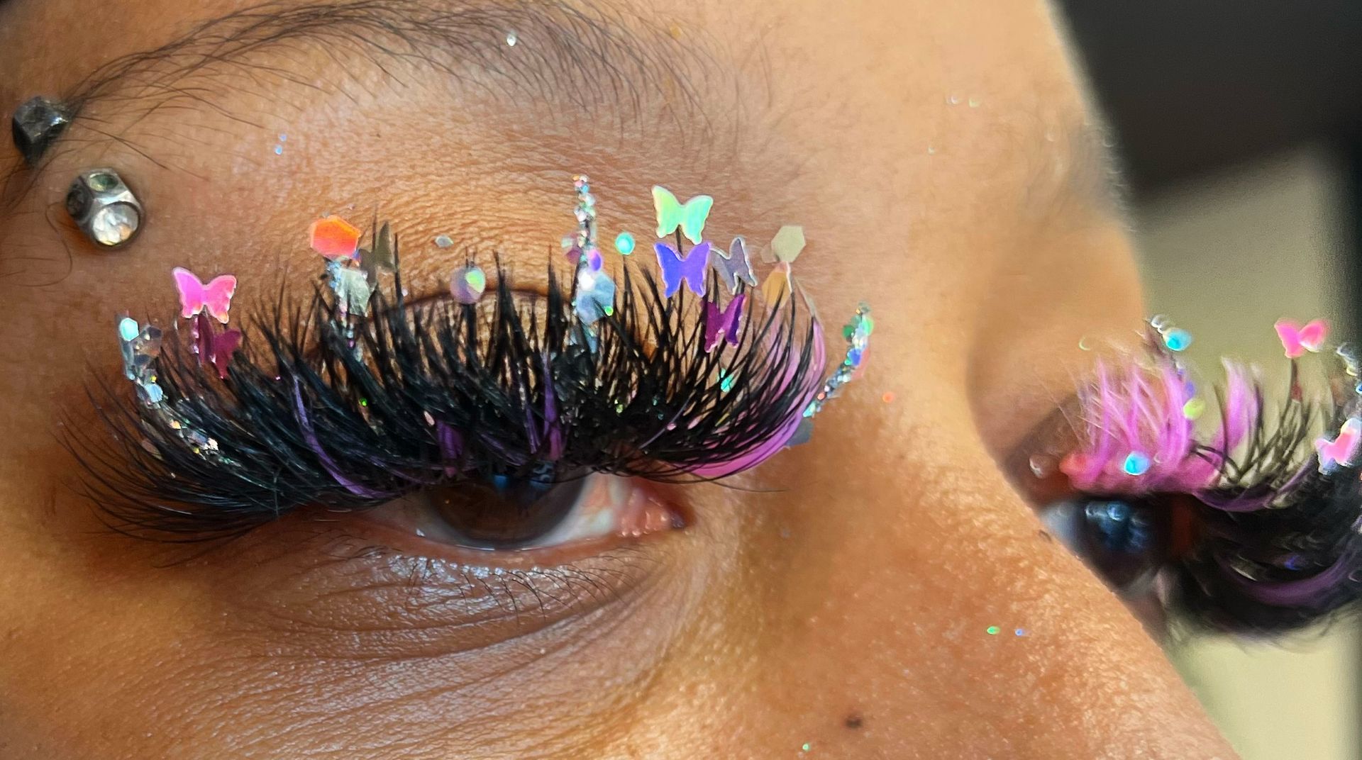 A close up of a woman 's eye with false eyelashes and glitter