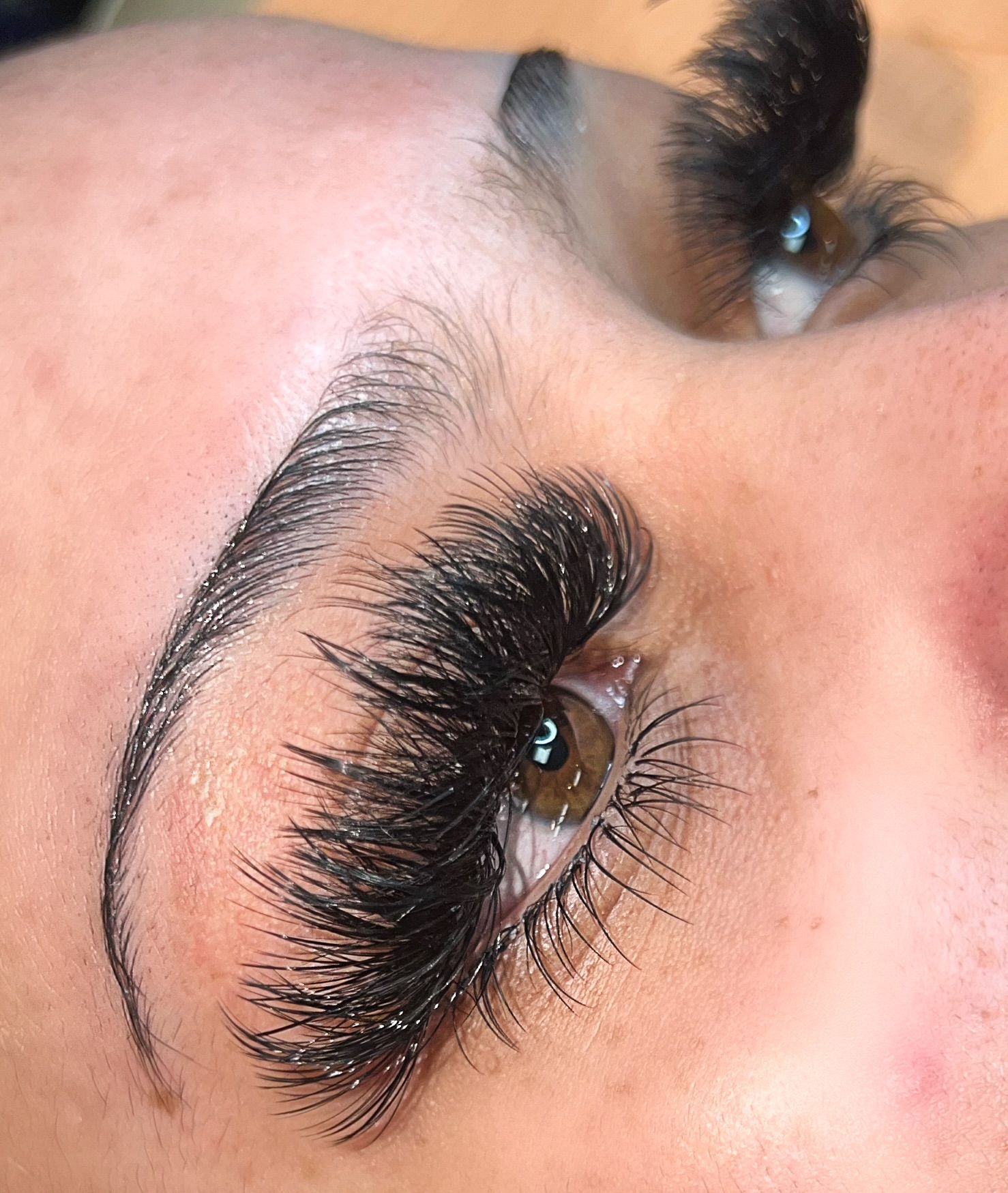 A close up of a woman 's eye with long eyelashes.