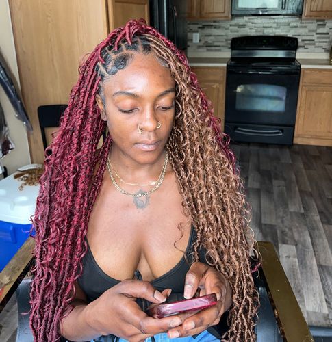 A woman with red braids is looking at her phone