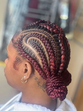 A woman with red braids in a bun is sitting in a chair.