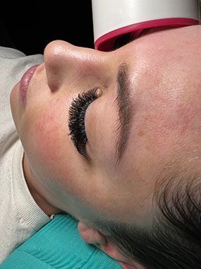 A close up of a woman 's face with long eyelashes.