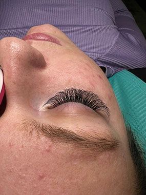 A close up of a woman 's face with long eyelashes.