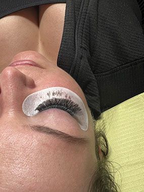 A close up of a woman 's eye with lashes on it.