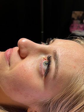 A close up of a woman 's face with long eyelashes.