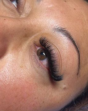 A close up of a woman 's eye with long eyelashes.