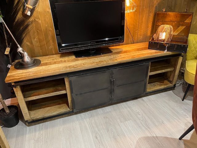 Un téléviseur à écran plat est posé sur un centre de divertissement en bois.