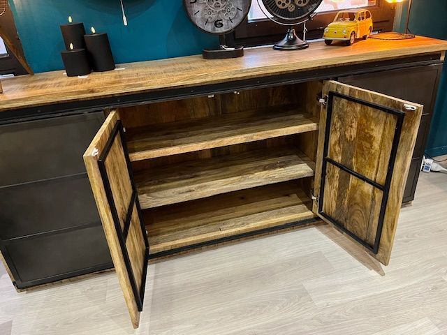 Une commode en bois avec une horloge sur le mur au-dessus.
