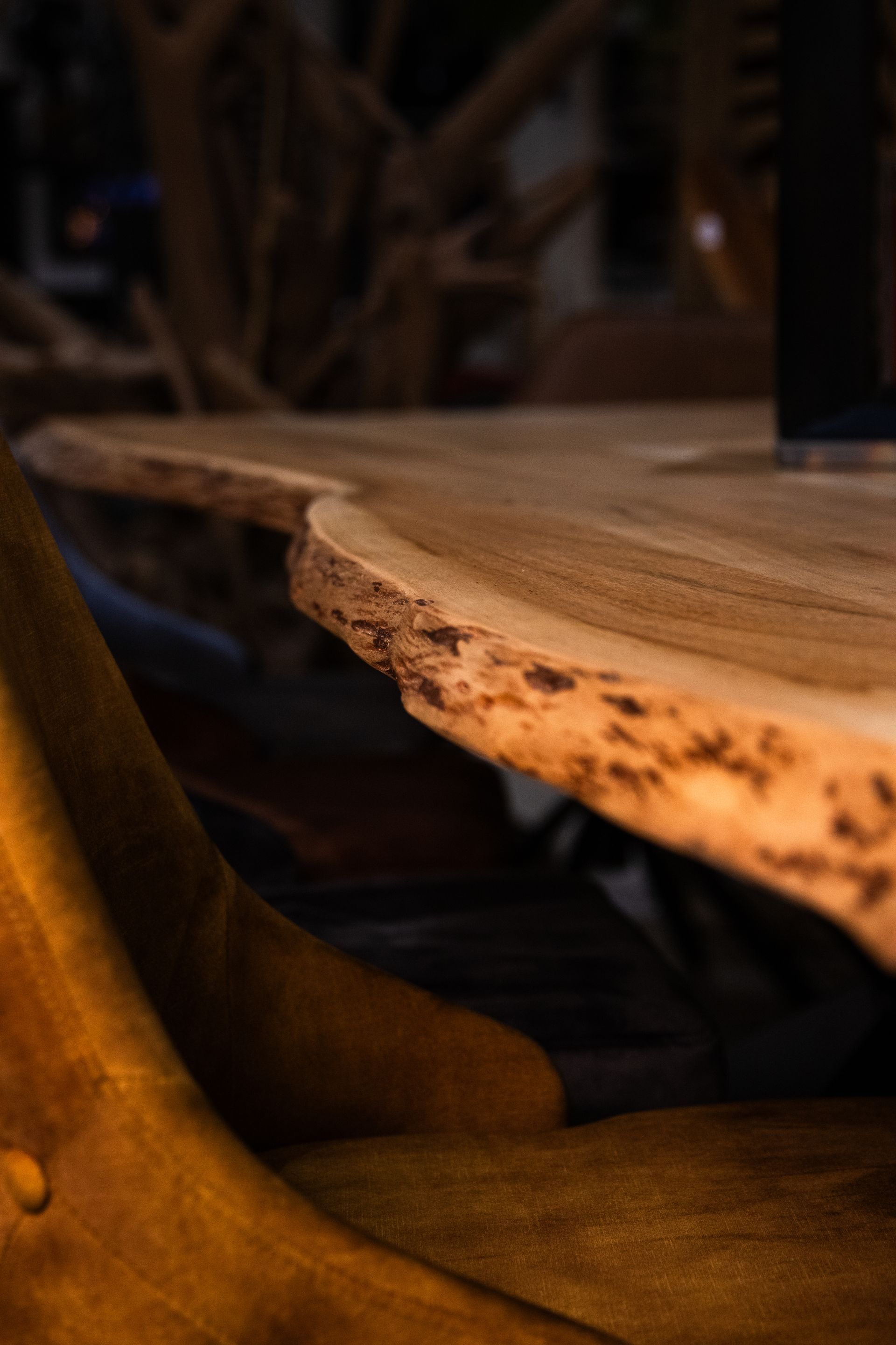Une table en bois avec une bougie dessus dans une pièce sombre
