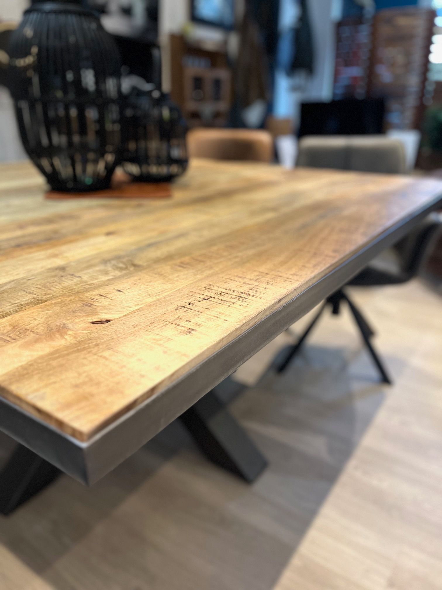 Une table et des chaises en bois sont posées sur un plancher en bois dans une pièce.