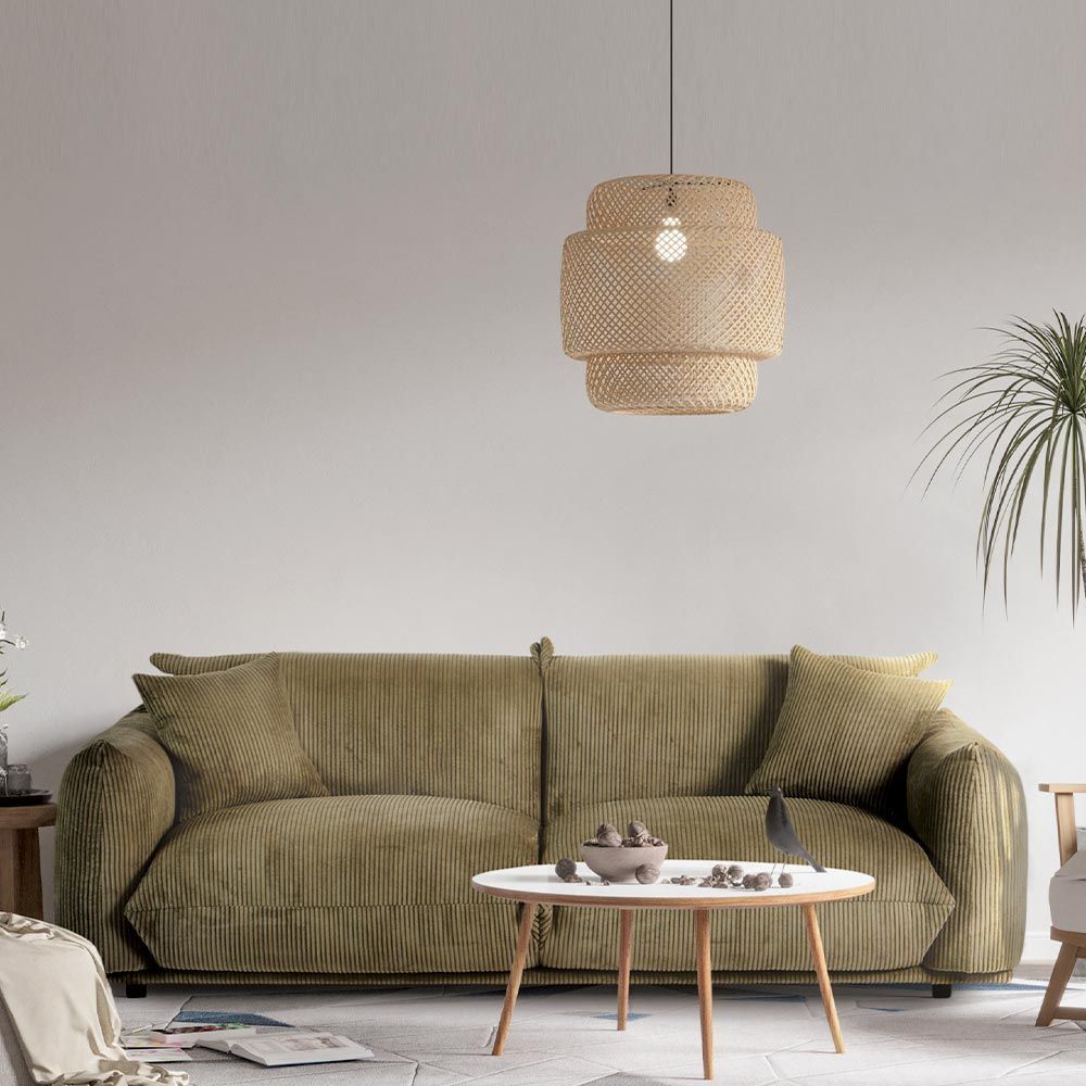 Canapé vert dans un salon avec une grande fenêtre et vue sur l'océan.