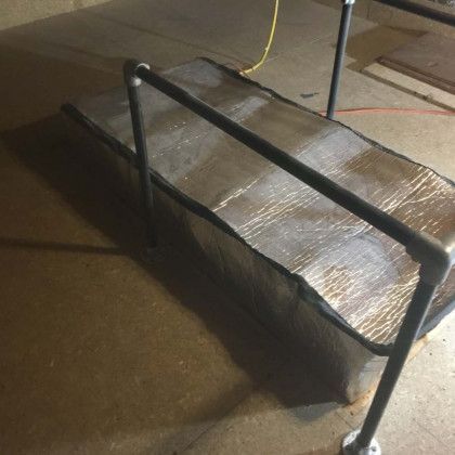 A metal railing is attached to a piece of aluminum foil